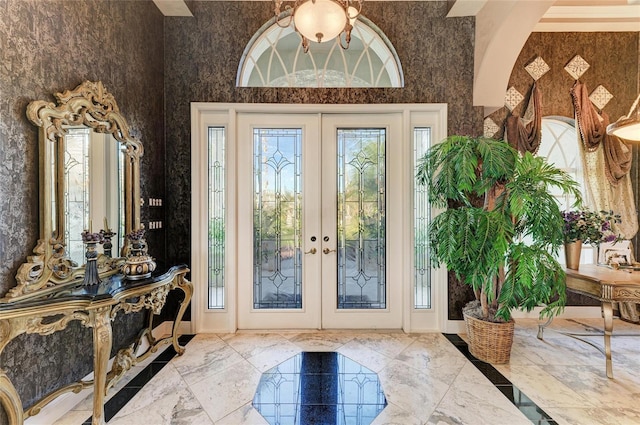 entrance foyer featuring marble finish floor, baseboards, french doors, and wallpapered walls