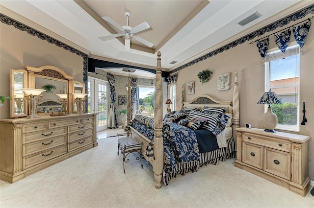 bedroom featuring access to exterior, french doors, a raised ceiling, light colored carpet, and visible vents