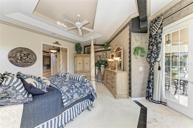 bedroom with a ceiling fan, a tray ceiling, access to outside, and baseboards