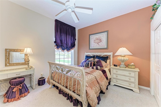 bedroom featuring ceiling fan, baseboards, and light colored carpet