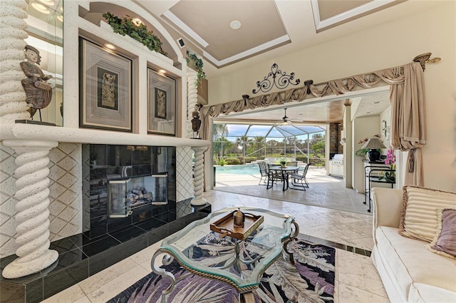 living area with a tile fireplace and a sunroom