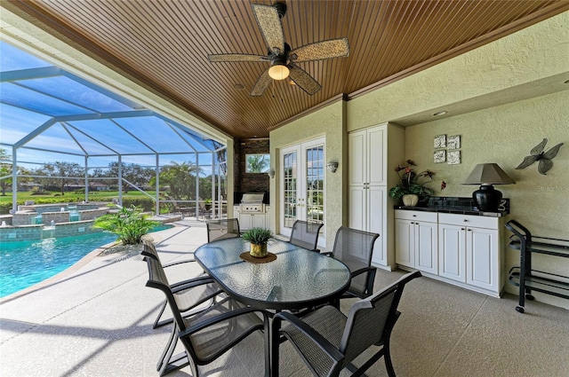 view of patio / terrace with a pool with connected hot tub, an outdoor kitchen, and french doors