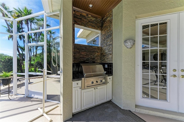 exterior space featuring stone siding, area for grilling, and stucco siding