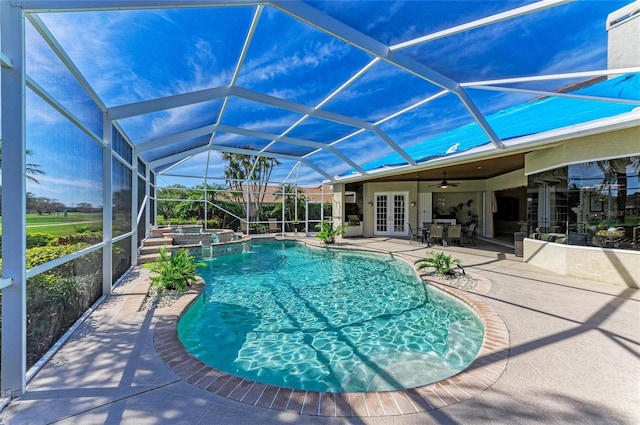 view of swimming pool featuring a patio, a lanai, a pool with connected hot tub, a ceiling fan, and french doors