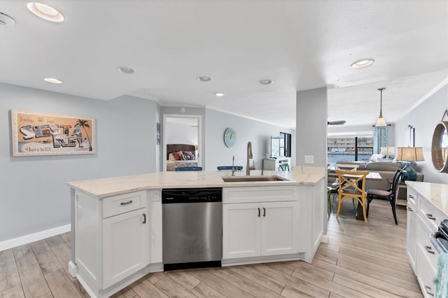 kitchen with wood tiled floor, open floor plan, white cabinets, a sink, and dishwasher