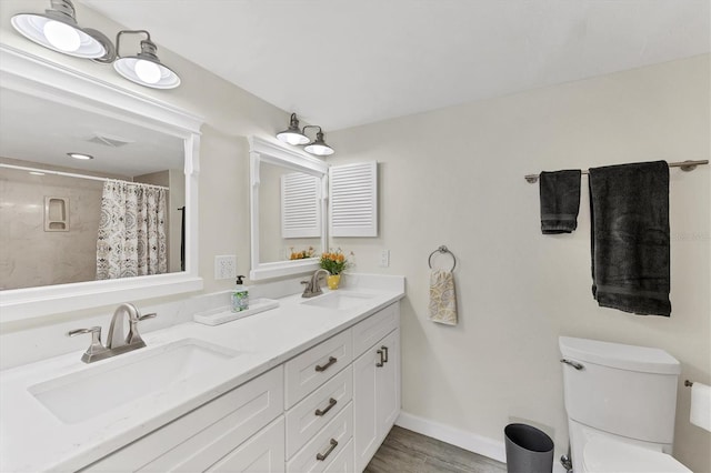 bathroom with visible vents, a sink, baseboards, and double vanity