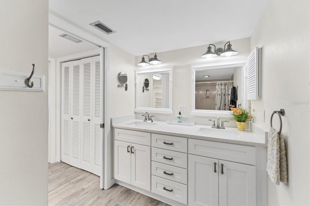 full bathroom with double vanity, a closet, visible vents, and a sink