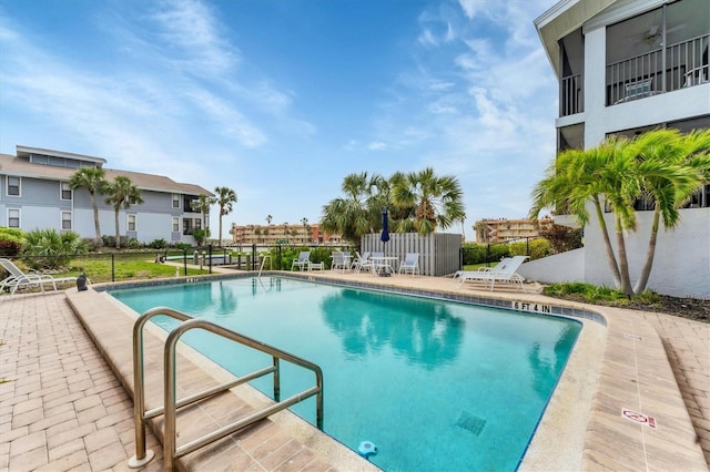 pool with a patio area and fence