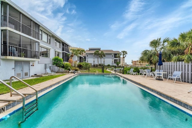 community pool featuring a patio area and fence