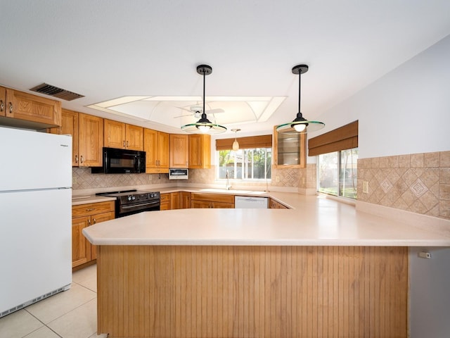 kitchen featuring light tile patterned floors, visible vents, light countertops, a peninsula, and black appliances