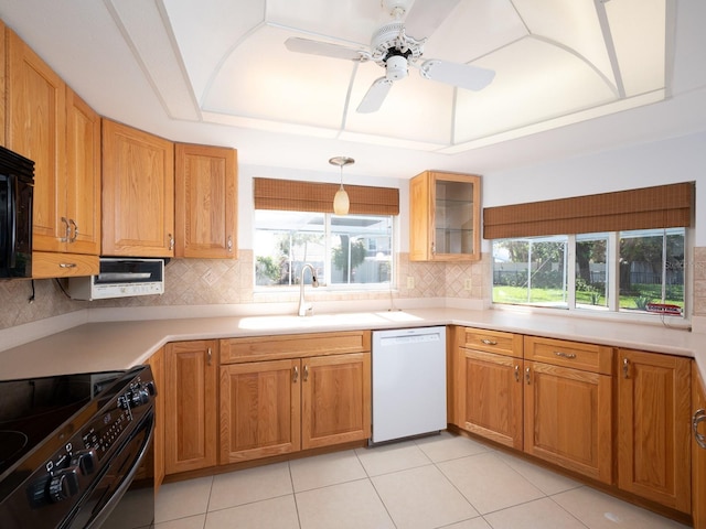 kitchen with black range with electric stovetop, a tray ceiling, light countertops, and dishwasher