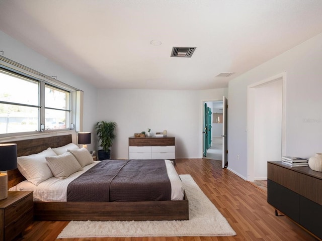 bedroom featuring visible vents and wood finished floors