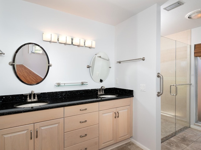 bathroom with a stall shower, visible vents, a sink, and double vanity