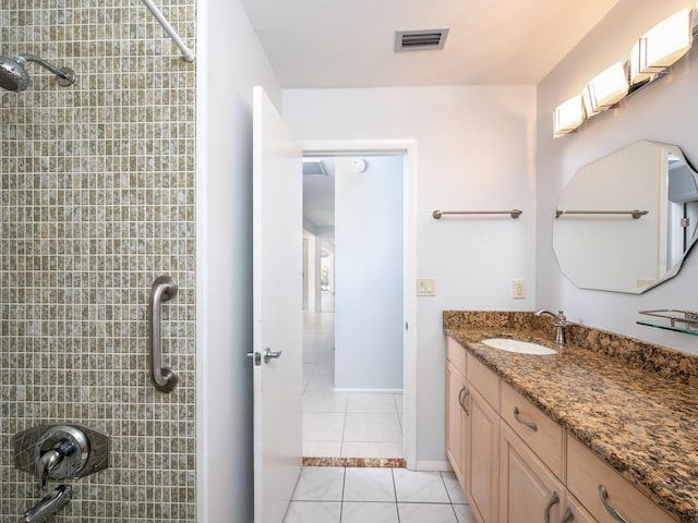 bathroom with visible vents, tiled shower, tile patterned flooring, and vanity