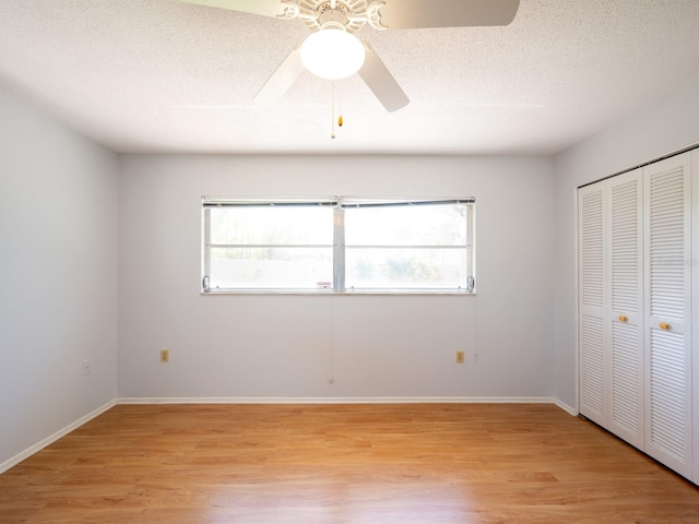 unfurnished bedroom with a textured ceiling, a closet, and light wood-style flooring