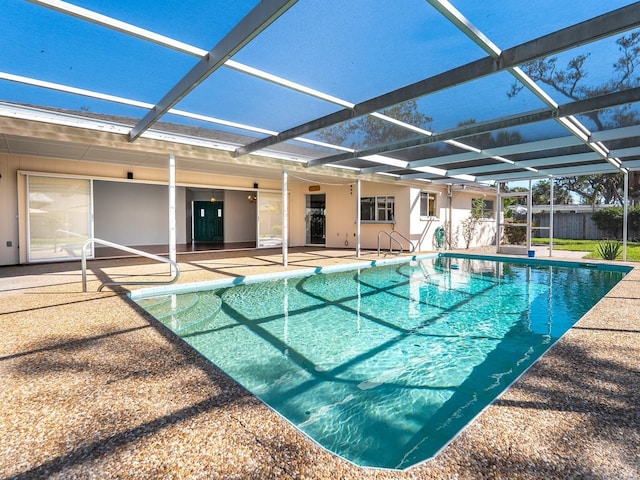 view of pool with glass enclosure, a patio area, fence, and a fenced in pool