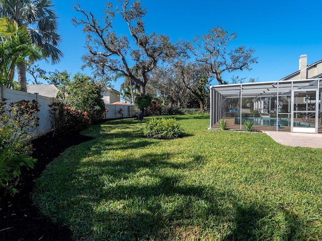 view of yard with a fenced backyard, a lanai, and a fenced in pool