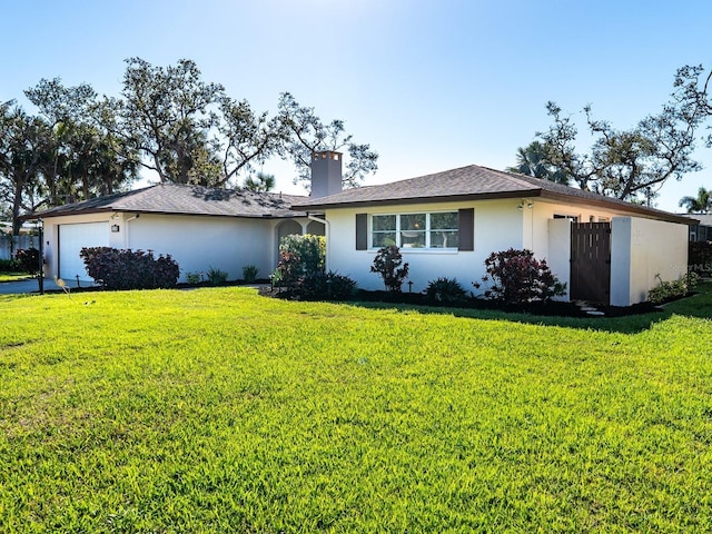 ranch-style home featuring a chimney, a front yard, an attached garage, and stucco siding