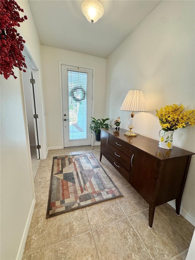 entryway featuring light tile patterned flooring and baseboards