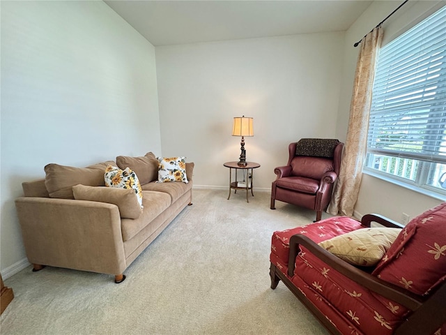 carpeted living area featuring baseboards