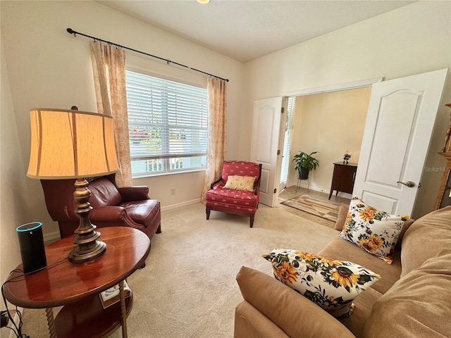 sitting room featuring light colored carpet and baseboards