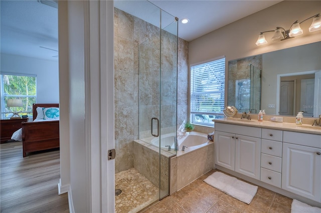 ensuite bathroom with plenty of natural light, a shower stall, a sink, and ensuite bathroom