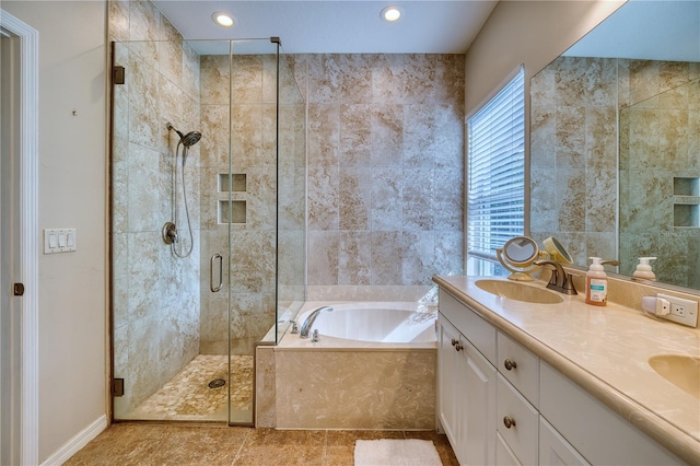 bathroom with double vanity, a garden tub, a shower stall, a sink, and recessed lighting