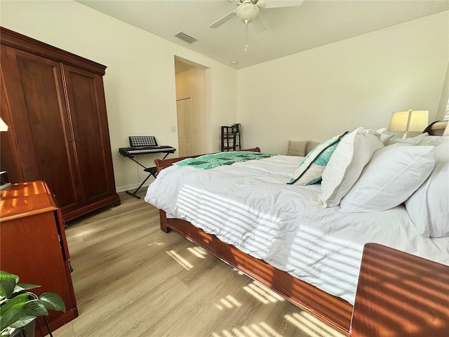 bedroom featuring a ceiling fan, light wood-type flooring, visible vents, and baseboards