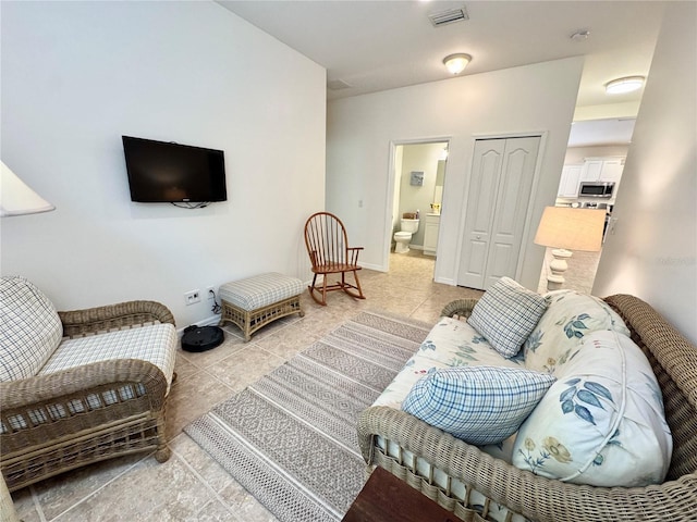 living area with visible vents, baseboards, and light tile patterned flooring