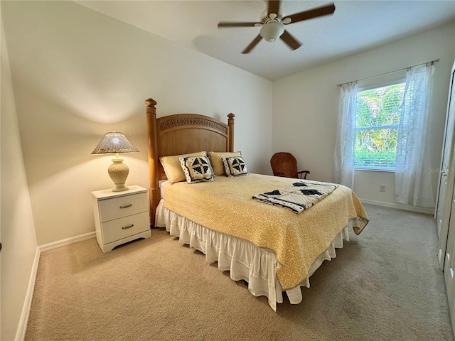 bedroom featuring light carpet, baseboards, and a ceiling fan