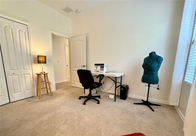 office space featuring baseboards, visible vents, and light colored carpet