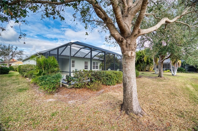 view of side of home with a lanai and a yard