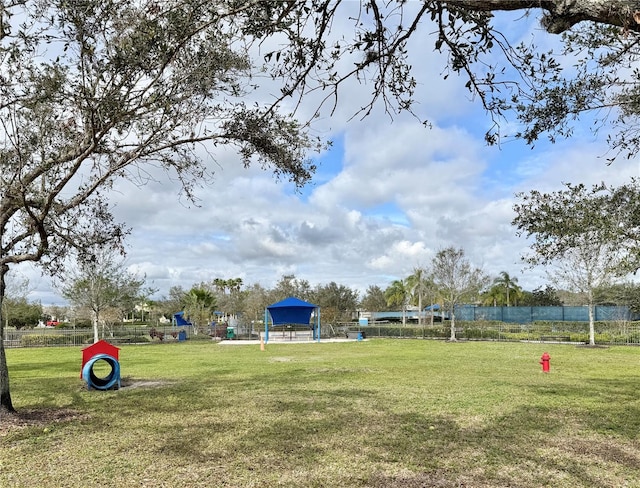 view of property's community featuring fence and a lawn