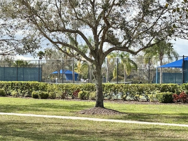 view of home's community with a yard and fence