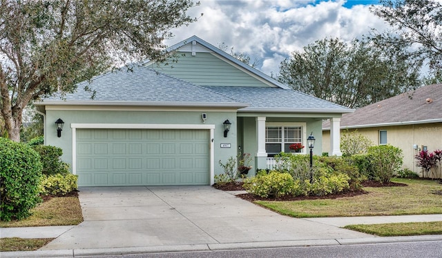 ranch-style house with covered porch, a garage, a shingled roof, concrete driveway, and stucco siding