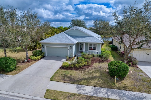 view of front of house featuring roof with shingles, stucco siding, covered porch, concrete driveway, and an attached garage