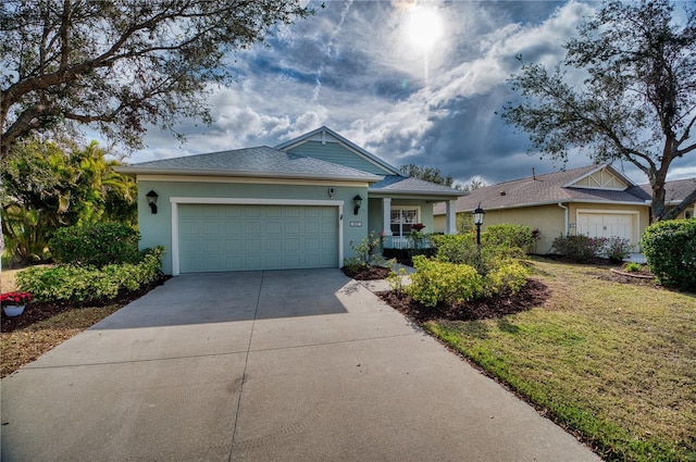 ranch-style home with driveway, an attached garage, covered porch, a front yard, and stucco siding