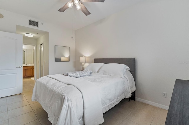 bedroom featuring ceiling fan, light tile patterned flooring, visible vents, baseboards, and ensuite bath