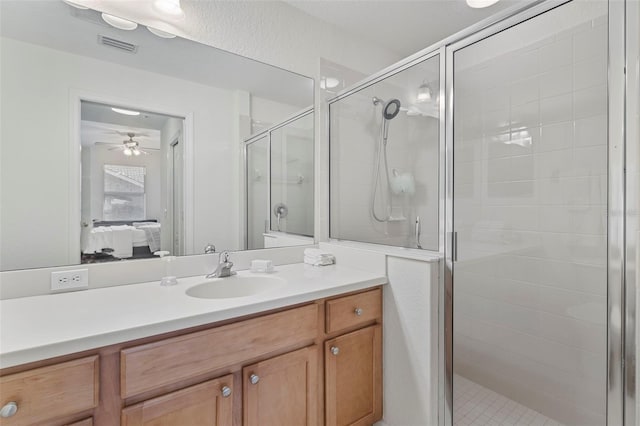 bathroom featuring visible vents, connected bathroom, a shower stall, and vanity