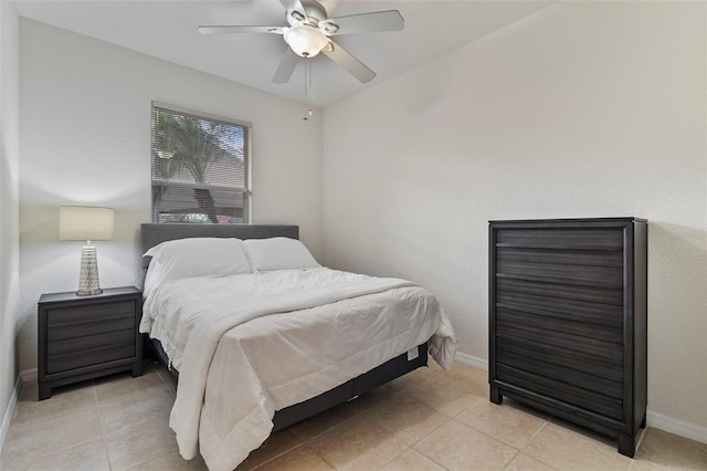 bedroom featuring light tile patterned flooring, a ceiling fan, and baseboards