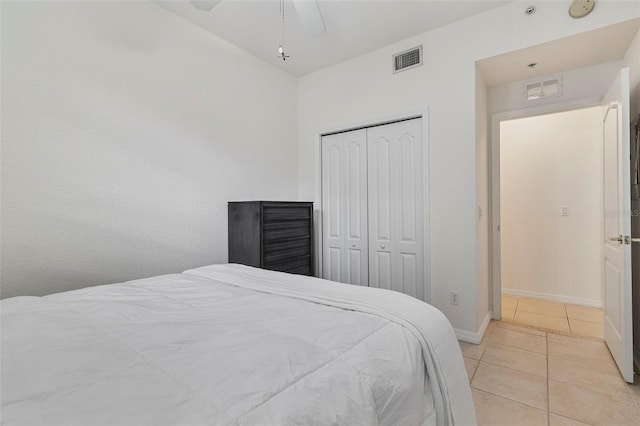 bedroom featuring a closet, light tile patterned flooring, visible vents, and baseboards