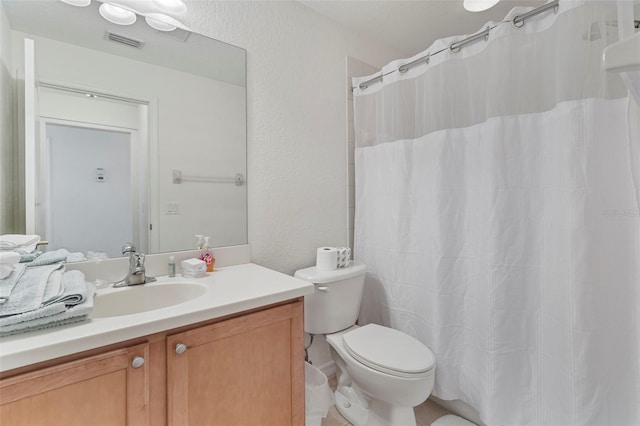 full bathroom featuring visible vents, a textured wall, toilet, vanity, and a shower with curtain