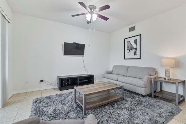 living room with baseboards, tile patterned flooring, visible vents, and a ceiling fan