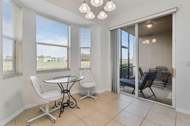 dining space featuring tile patterned flooring, baseboards, and an inviting chandelier