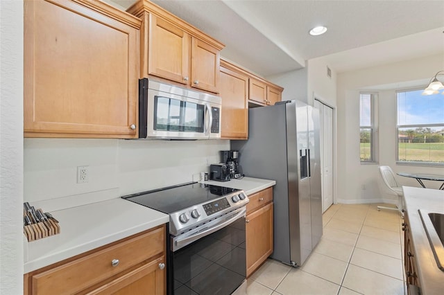 kitchen with light tile patterned floors, light countertops, appliances with stainless steel finishes, and visible vents