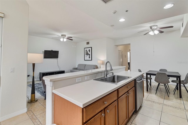 kitchen featuring a sink, open floor plan, light countertops, brown cabinets, and dishwasher