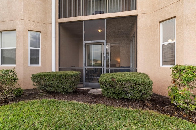 doorway to property featuring stucco siding