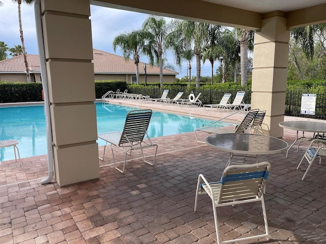 pool with fence and a patio