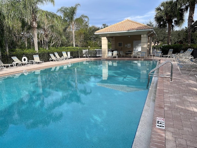 community pool with fence and a patio