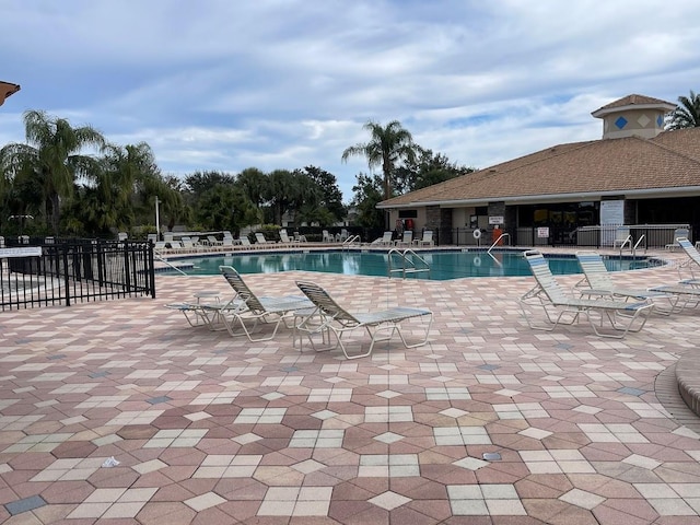 pool with fence and a patio